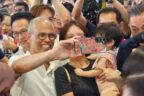 Penduduk Tampines beratur untuk bergambar dengan Menteri Pembangunan Sosial dan Keluarga, Encik Masagos Zulkifli Masagos Mohamad di Blok 633 Tampines North Drive 2 pada 30 April.