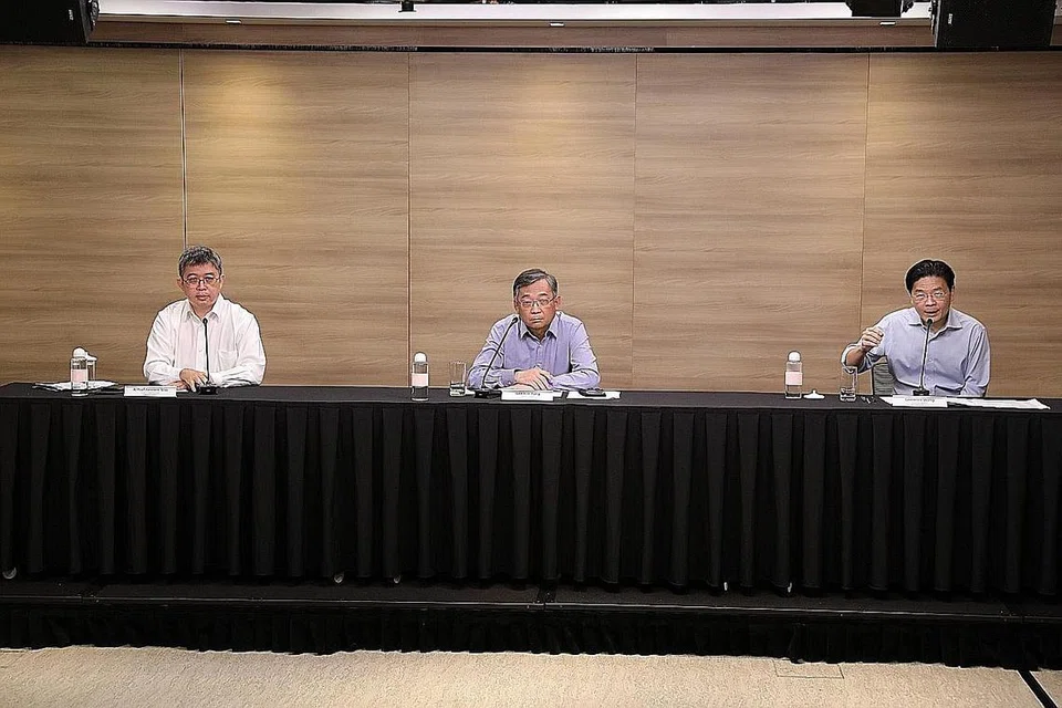 PERJELAS PENTINGNYA VAKSINASI:(Kiri) Pengarah khidmat perubatan di MOH, Profesor Madya Kenneth Mak menegaskan kepentingan semua warga mendapatkan vaksinasi apabila peluang melakukan demikian diberikan. Di sebelahnya ialah Menteri Kesihatan Encik Gan Kim Yong dan Menteri Pendidikan Encik Lawrence Wong. - Foto MCI