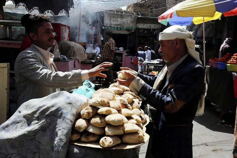 Seorang penjaja menjual roti di sebuah pasar di bandar lama Sana'a, Yaman. 