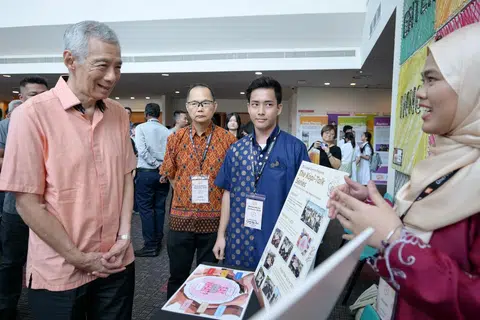 Menteri Kanan, Encik Lee Hsien Loong (kiri), berkunjung ke pameran sempena Sidang HarmonyWorks! anjuran OnePeople.sg di ITE Kolej Timur.
