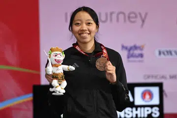 Atlet lawan pedang negara, Kiria Tikanah Abdul Rahman, tersenyum sambil memegang pingat gangsa yang dimenanginya dalam acara ‘epee’ individu wanita di Kejohanan Lawan Pedang Asia 2025 di Bali, Indonesia.