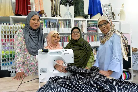 SOKONGAN KELUARGA: (Dari kiri) Cik Rabiatuladawiyah mendapat sokongan ibunya, Cik Latifah Suradi; neneknya, Cik Alfiah, dan mak ciknya, Cik Siti Khairiah Suradi, untuk menyambung perniagaan menjahit yang dimulakan neneknya. - Foto BH oleh M.O. SALLEH