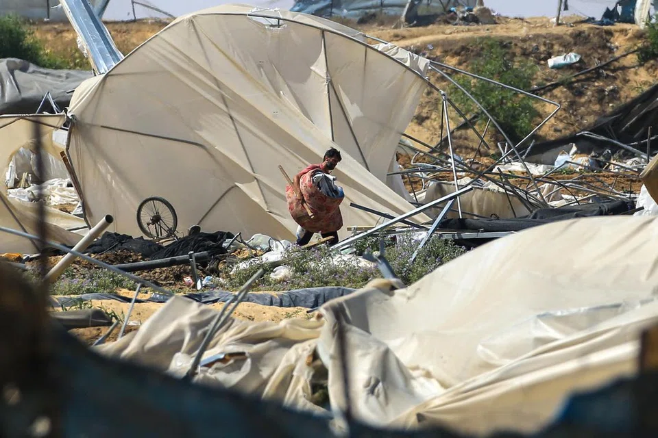 Seorang lelaki mencari-cari barang-barang yang bermanfaat, selepas satu serangan Israel di Rafah, di selatan Gaza, pada 29 Jun.