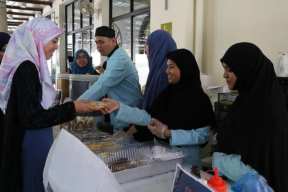 GOTONG-ROYONG KUMPUL DANA: Selain berinteraksi dengan orang ramai dalam acara di Masjid Al-Abdul Razak, pelajar istimewa dari MIJ Education Hub berganding bahu bersama sukarelawan menjual pelbagai barang termasuk makanan, untuk mengumpul dana bagi institusi mereka.