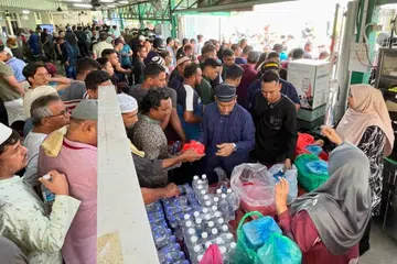 Jemaah masjid mengambil makanan yang diderma oleh para penderma selepas solat Jumaat di Masjid Al-Firdaus.