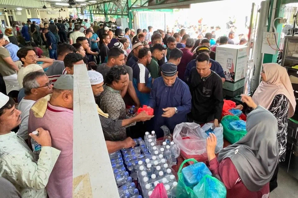 Jemaah masjid mengambil makanan yang diderma oleh para penderma selepas solat Jumaat di Masjid Al-Firdaus.