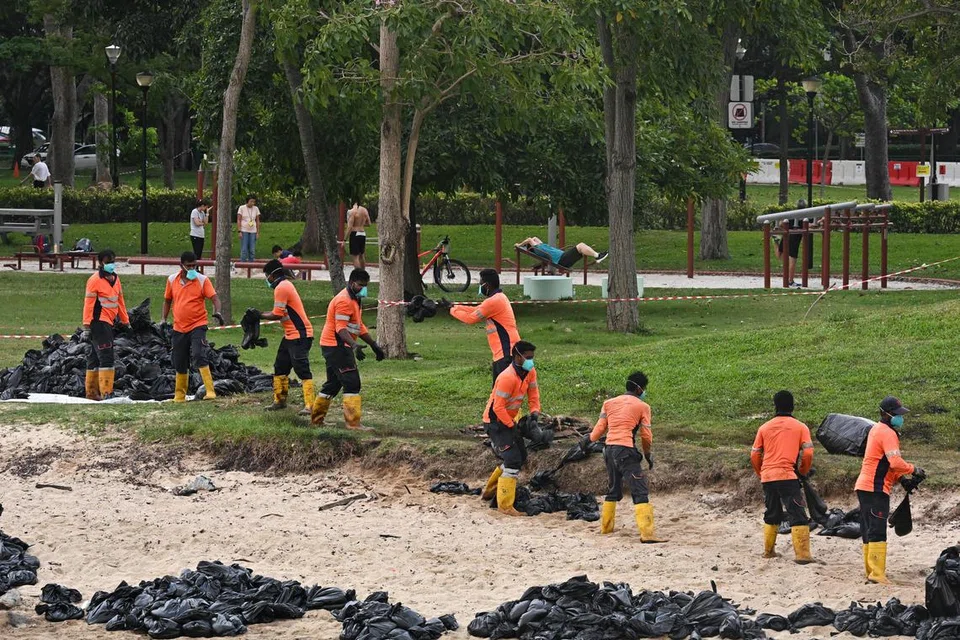 Pekerja giat membersihkan tumpahan minyak di Taman East Coast pada 19 Jun.