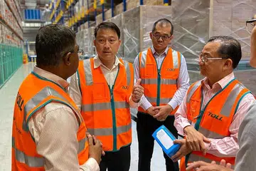 TINJAU BEKALAN: Dr Lam Pin Min (dua dari kiri) dan Encik Seah Kian Peng (kanan) melawat salah sebuah gedung untuk memeriksa bekalan pelitup di Singapura. - Foto: FACEBOOK/Dr Lam Pin Min