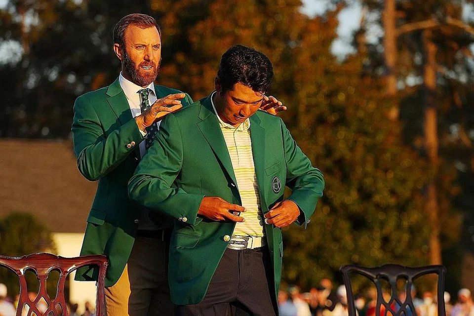 BANGGA: Matsuyama (depan) dibantu memakai 'jaket hijau' bagi juara oleh pemenang di Augusta tahun lalu, Dustin Johnson. - Foto AFP