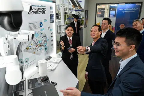 Encik Tan Kiat How (tengah) dan Encik Hugo Cai (kanan) mempelajari teknologi pengawasan bijak seperti kamera keselamatan, daripada pelajar kursus Nitec Lanjutan dalam Kejuruteraan Elektronik di ITE Kolej Timur, Cik Phoebe Goh Pei Ci (kiri).