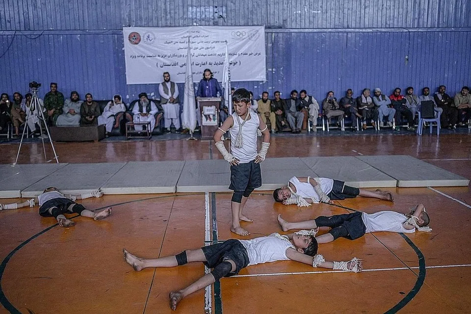 TUNJUK KEBOLEHAN BERSUKAN: Remaja Afghanistan menunjukkan kemahiran mereka dalam satu acara sukan yang dianjurkan sempena lawatan Pengarah Sukan dan Pendidikan Jasmani, Encik Bashir Ahmad Rustamzai, di sebuah jimnasium di ibu kota Kabul kelmarin. - Foto AFP 
