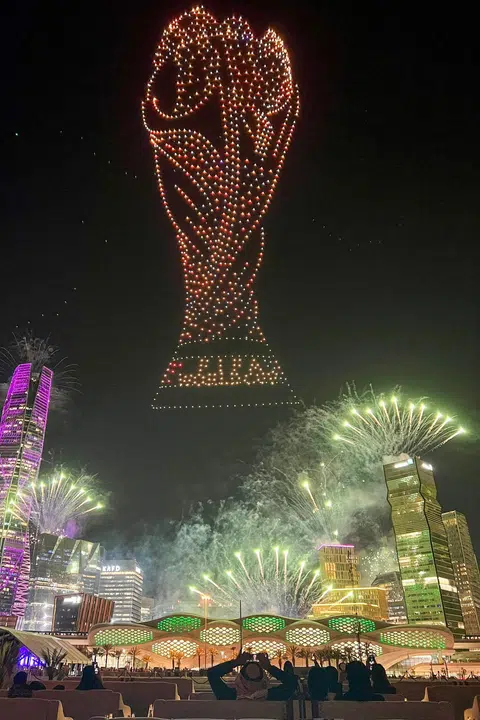 Orang ramai menyaksikan pertunjukan cahaya dron dan bunga api menerangi langit Riyadh pada 11 Disember, sempena sambutan pengesahan Arab Saudi sebagai tuan rumah kejohanan bola sepak Piala Dunia 2034.