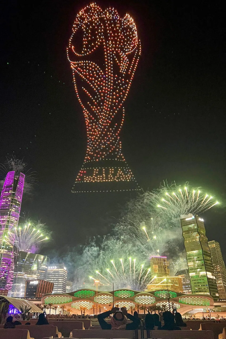 Orang ramai menyaksikan pertunjukan cahaya dron dan bunga api menerangi langit Riyadh pada 11 Disember, sempena sambutan pengesahan Arab Saudi sebagai tuan rumah kejohanan bola sepak Piala Dunia 2034.