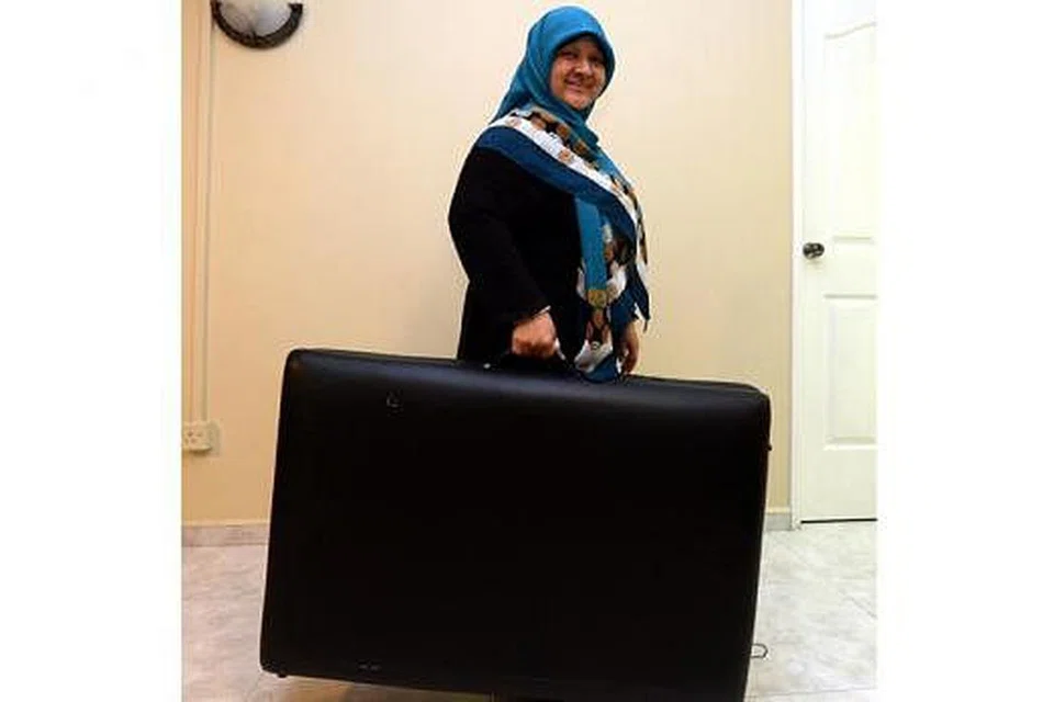 BUKAN SEBARANG BEG: Setiap kali Cik Fauziah perlu bertemu dengan klien di rumah mereka, beliau akan membawa katil urut yang boleh dilipat seakan-akan bagasi. 