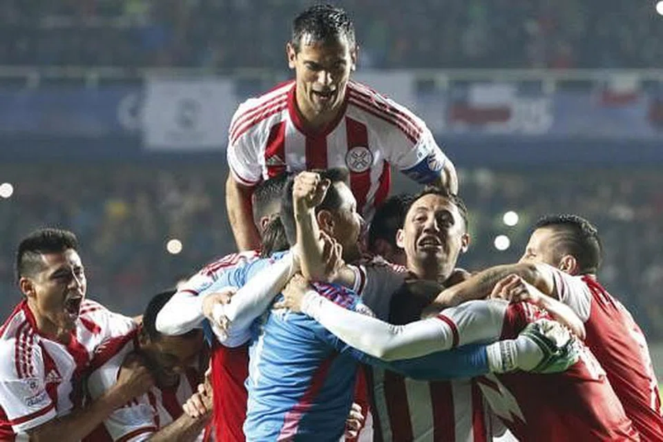 WIRA DIKERUMUNI: Wira Paraguay, Derlis Gonzalez (kanan, terselindung), dikerumuni dan dipeluk rakan-rakan lain sebaik kemenangan hebat ke atas Brazil semalam. - Foto REUTERS