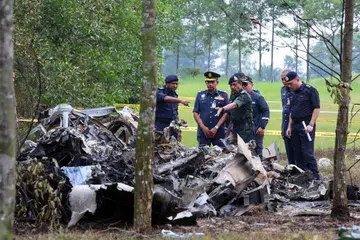 TINJAU TAPAK NAHAS: Ketua Polis Negara Malaysia, Tan Sri Razarudin Husain (tiga dari kiri), melihat beberapa bahagian pesawat yang telah terhempas di Lebuhraya Guthrie berdekatan Bandar Elmina, Selangor, petang Khamis.