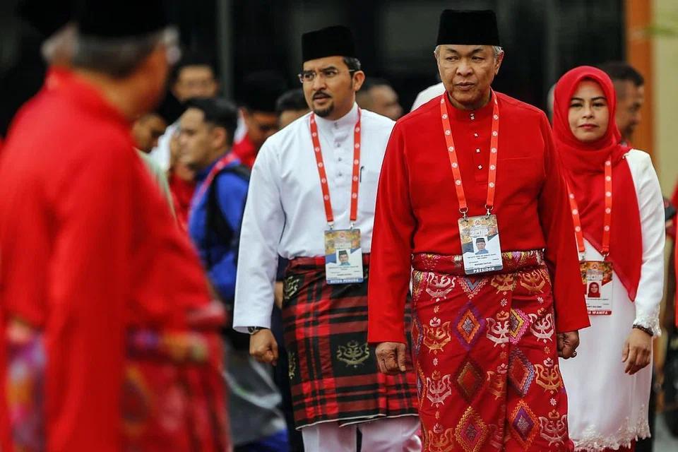 HURAI PERSOALAN: Presiden Umno, Datuk Seri Ahmad Zahid Hamidi (tengah); diiringi Ketua Pemuda Dr Asyraf Wajdi Dusuki dan Ketua Wanita Noraini Ahmad; memasuki dewan Perhimpunan Agung Umno 2018. Datuk Ahmad Zahid berkata dalam ucapan penggulungan perhimpunan bahawa jika mereka kuat dalam gagasan pembangkang, lebih lima juta pengundi dijangka sedia bersama. - Foto EPA-EFE