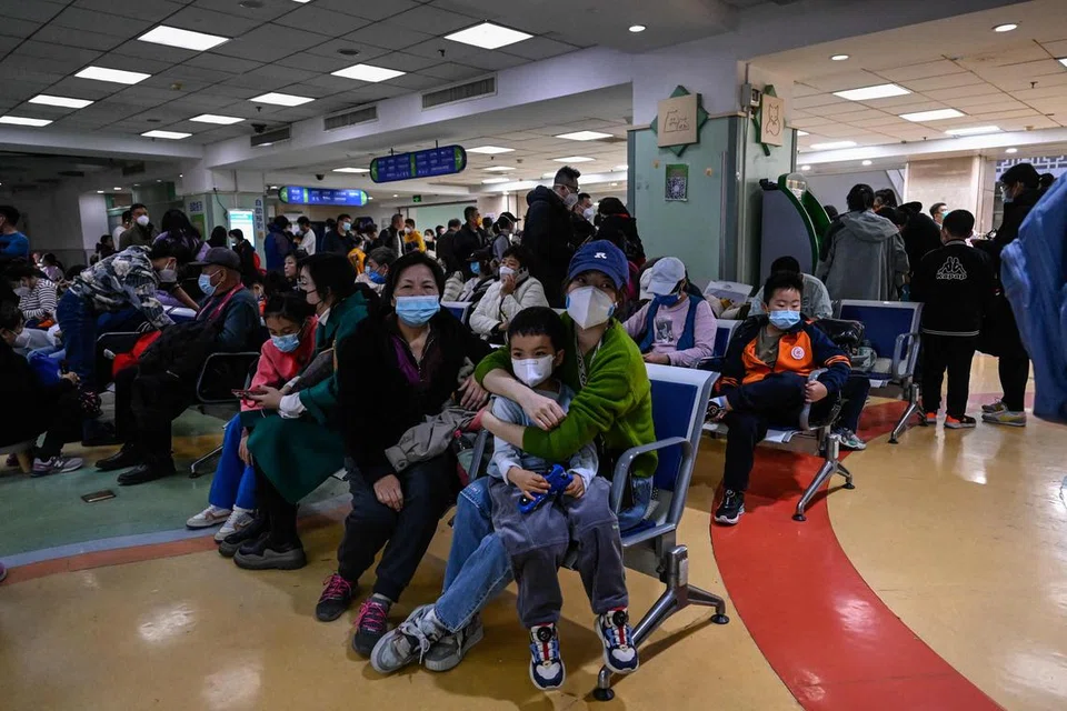 HOSPITAL SESAK: Ibu bapa bersama anak menunggu di kawasan pesakit luar di hospital kanak-kanak yang sesak di Beijing pada 23 November. 