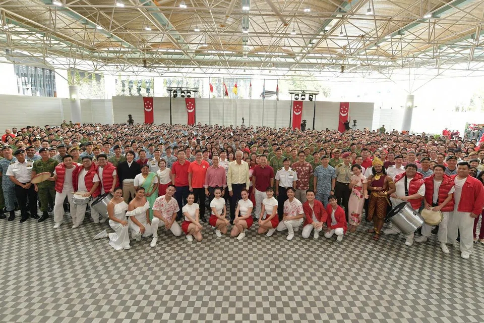MERAIKAN KEMERDEKAAN NEGARA: Menteri Pertahanan, Dr Ng Eng Hen (tengah, berbaju kuning) dan Menteri Negara Kanan (Pertahanan) Encik Zaqy Mohamad (di kanan Encik Ng), bersama-sama kakitangan Mindef dan SAF serta peserta dari So Drama! Entertainment semasa upacara rai Hari Kebangsaan yang diadakan di Mindef pada Selasa.