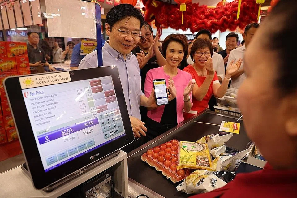 SKIM BAUCAR CDC 2023: Encik Lawrence Wong (kiri) menggunakan baucar CDC untuk membeli barangan di pasar raya FairPrice. Di bawah skim tahun ini, yang dilancarkan oleh beliau semalam, isi rumah warga Singapura boleh menggunakan separuh daripada baucar berjumlah $300 untuk berbelanja di lebih 300 cawangan pasar raya NTUC FairPrice, Sheng Siong, Prime Supermarket, HAO Mart dan U Stars Supermarket. - Foto BH oleh ONG WEE JIN