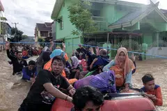TINGGALKAN RUMAH: Para penduduk mengosongkan rumah mereka di Makassar menyusuli hujan lebat dan angin kencang yang melanda bahagian selatan pulau Sulawesi, menyebabkan air sungai melimpahi tebing membanjiri kawasan di sembilan daerah selatan. Banjir kilat dan tanah runtuh yang berlaku pada hujung bulan lalu itu mengakibatkan puluhan orang terkorban dan ramai terpaksa berpindah. - Foto AFP