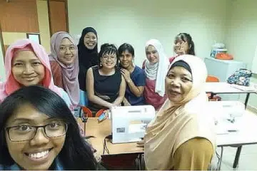 TINGGALKAN SEMENTARA: Cik Kamaria (bertudung, di depan) bersama beberapa pelajar yang menyertai kelas jahitannya, yang akan ditutup sementara beliau menunaikan fardu haji. - Foto ihsan KAMARIA BUANG