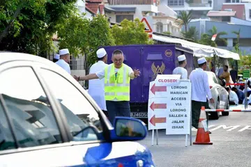 Relawan dari Shinnyo-en membantu menguruskan trafik semasa solat Aidilfitri di Masjid Abdul Razak pada 11 Ogos.