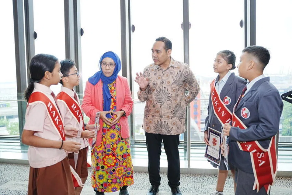 Anggota Parlimen GRC Chua Chu Kang, Encik Zhulkarnain Abdul Rahim (empat dari kiri) berbual dengan beberapa pelajar di majlis pelantikan Rakan Bahasa pada 2025. Beliau dilantik sebagai Menteri Negara (Ehwal Luar merangkap Pembangunan Sosial dan Keluarga). 