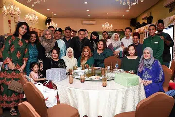 BERAYA DI RESTORAN: Encik Adib Mattar (berdiri tengah, berbaju hitam) bersama sanak saudaranya menyambut Hari Raya di sebuah restoran tahun lalu. - Foto ihsan ADIB MATTAR