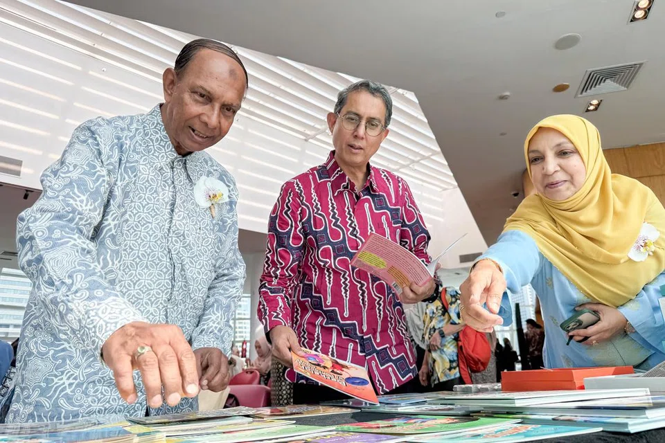 Pasangan suami isteri yang mengendalikan syarikat penerbitan Alam Cahaya, Encik Rudin Mohd (kiri) dan Cik Hana Mohd, menunjukkan buku-buku Melayu yang diterbitkan syarikat mereka kepada Pemangku Menteri Bertanggungjawab bagi Ehwal Masyarakat Islam, Profesor Madya Dr Faishal Ibrahim.