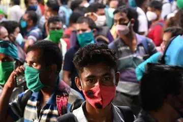 PERINTAH BERKURUNG DILAKSANA: Ramai yang beratur di stesen bas di Kolkata bagi membeli tiket pulang ke rumah selepas pemerintah Bengal Barat di India mengumumkan perintah berkurung selama 15 hari bagi mengekang penularan wabak Covid-19. - Foto DIBYANGSHU SARKAR/AFP