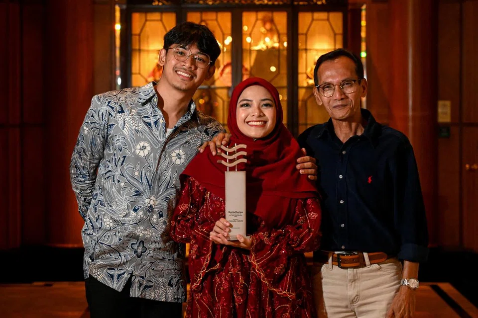 Penerima Jauhari Harapan 2024, Cik Zulayqha Zulkifli (tengah), meraikan anugerahnya bersama ayahnya, Encik Zulkifli Atnawi (kanan) dan adiknya, Encik Zulfeqar Zulkifli (kiri).