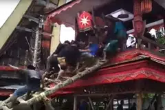 DITIMPA KERANDA: Orang ramai naik tangga untuk meletakkan keranda dalam lakkean sebelum tangga itu tiba-tiba runtuh dan keranda menimpa mereka.