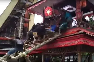 DITIMPA KERANDA: Orang ramai naik tangga untuk meletakkan keranda dalam lakkean sebelum tangga itu tiba-tiba runtuh dan keranda menimpa mereka.