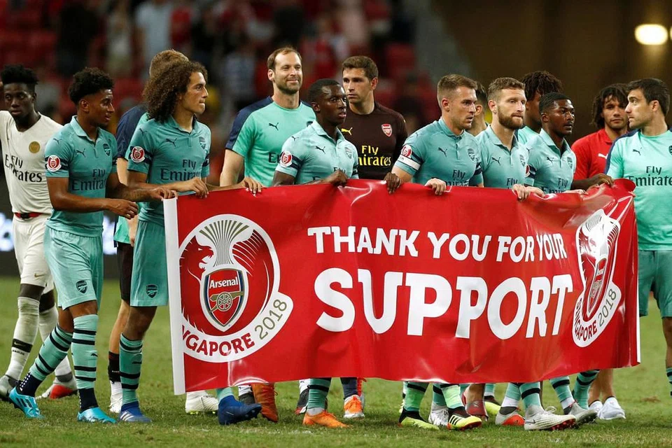 TERIMA KASIH: Sebagai tanda penghargaan kepada para penyokong Arsenal, pemain Arsenal membawa sepanduk mengelilingi Stadium Negara selepas perlawanan terakhir mereka di ICC Singapura Sabtu lalu. - Foto REUTERS