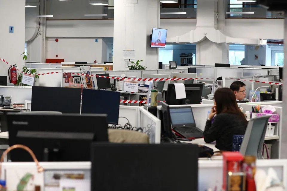 KEBIASASAN BARU: Bilik berita di Singapore Press Holdings (SPH) lengang selepas kakitangannya dibahagikan kepada sekurang-kurangnya dua kumpulan - yang bekerja di pejabat dan yang di rumah. Ini kebiasaan baru di tempat-tempat kerja lain juga. - Foto BH oleh BENJAMIN SEETOR