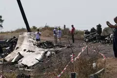 JALANKAN SIASATAN: Seorang penyiasat dari Malaysia (kanan) sedang melakukan kerja siasatan di tapak terhempasnya MH17 berdekatan kampung Hrabove (Grabovo), kawasan Donetsk. - Foto REUTERS