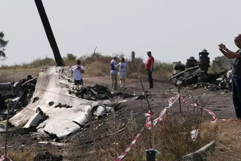 JALANKAN SIASATAN: Seorang penyiasat dari Malaysia (kanan) sedang melakukan kerja siasatan di tapak terhempasnya MH17 berdekatan kampung Hrabove (Grabovo), kawasan Donetsk. - Foto REUTERS