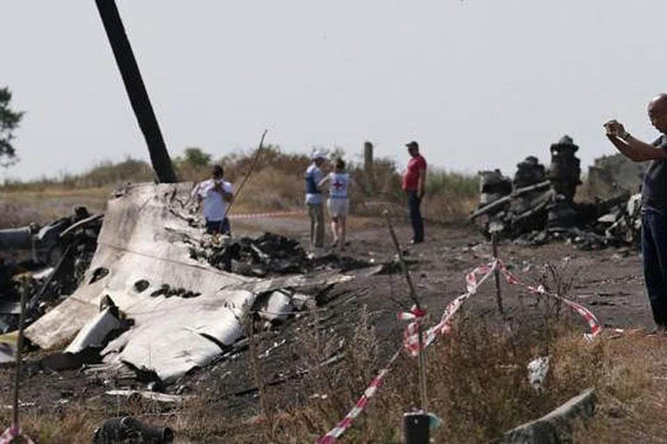 JALANKAN SIASATAN: Seorang penyiasat dari Malaysia (kanan) sedang melakukan kerja siasatan di tapak terhempasnya MH17 berdekatan kampung Hrabove (Grabovo), kawasan Donetsk. - Foto REUTERS