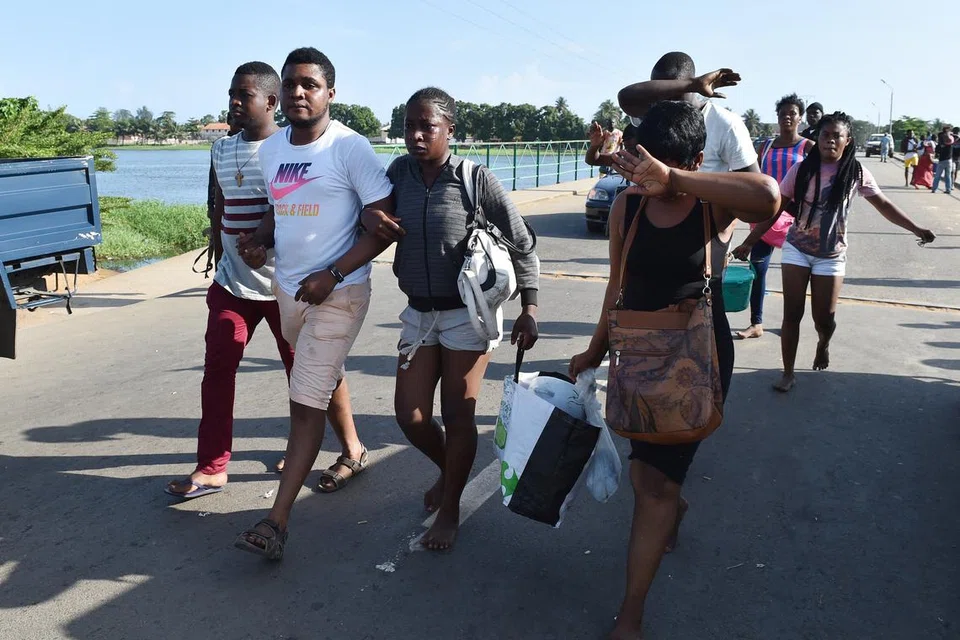 TINGGALKAN TEMPAT KEJADIAN: Orang ramai meninggalkan kawasan pantai selepas serangan di sebuah resort di Ivory Coast. -- Foto AFP