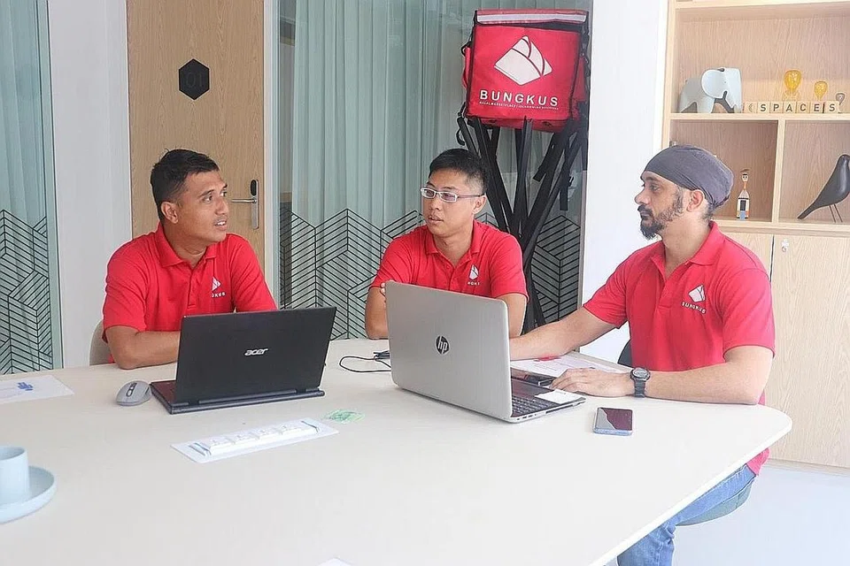 LEBIH BANYAK TEMPAHAN: Encik Mohamed Azahari Abdul Aziz (paling kiri) yakin tempahan makanan Halal dalam talian akan terus diminati ramai dan kekal lama di sini. Beliau kelihatan berbincang bersama rakan kerjanya (dari kiri) Encik Gabriel Tan dan Encik Baru Walia. - Foto ihsan MOHAMED AZAHARI ABDUL AZIZ