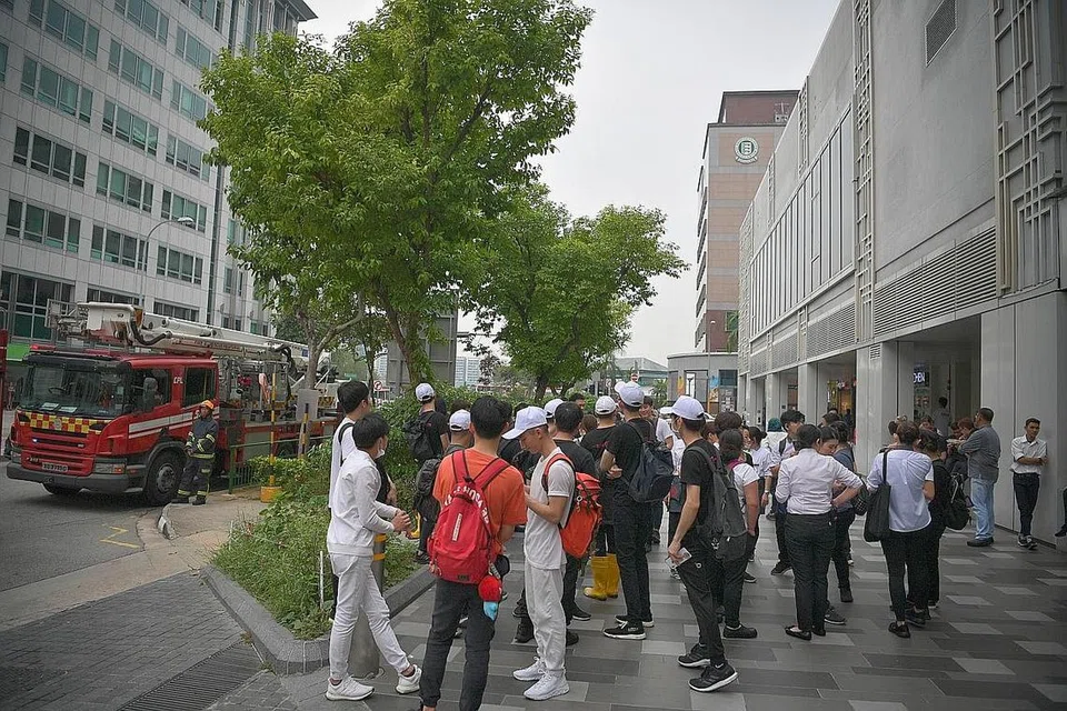 DIPINDAH KELUAR: Pelanggan dan kakitangan Century Squre menunggu di luar pusat beli-belah itu di Tampines selepas berlakunya kebakaran di tingkat tiga bangunan itu. - Foto BH oleh ARIFFIN JAMAR