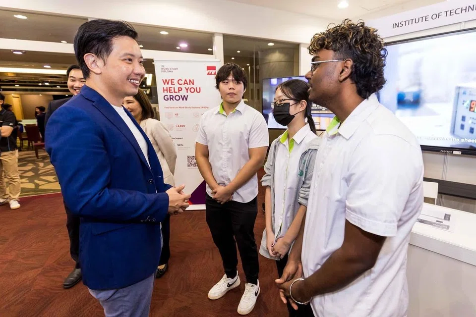 Menteri Negara (Perdagangan dan Perusahaan), Encik Alvin Tan (kiri), bersembang dengan pelajar Institut Pendidikan Teknikal (ITE) yang berminat dalam industri semikonduktor pada majlis pemeteraian perjanjian antara ITE dengan pengeluar cip Jerman, Siltronic, dan syarikat Taiwan, Vanguard International, pada 21 Januari.