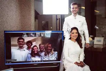 TEKNOLOGI RAPATKAN UKHUWAH WALAU JAUH: Farisha Ishak dan suami Encik Connor Cooke yang berasal dari North Carolina, Amerika, bernikah di Singapura baru-baru ini dengan keluarga Encik Cooke (dalam kaca televisyen) menyaksikan upacara akad nikah menerusi aplikasi Zoom.- Foto FANDY RAZAK