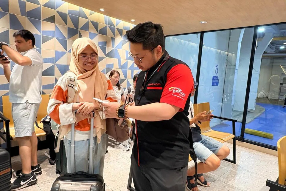 Ketua Pegawai Eksekutif ttklia.com yang mengendalikan LTH itu, Encik Aaron Chuah (kanan), membantu seorang penumpang yang menggunakan perkhidmatan pengangkutan bas ekspres Kuala Lumpur-Singapura di LaLaport Transportation Hub, di Bukit Bintang City Centre, Kuala Lumpur.