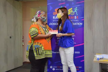 BANTUAN RINGANKAN BEBAN: Cik Aida Ayob (kiri) menerima baucar barangan runcit daripada Cik Tin Pei Ling, dalam satu majlis di Pusat Khidmat Keluarga THK @ MacPherson. - Foto BH oleh ALPHONSUS CHERN
