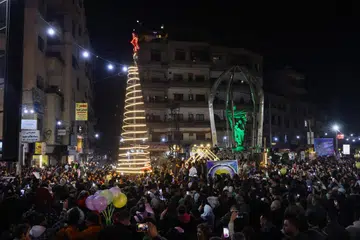Para penduduk meraikan acara penyalaan pokok Krismas di kawasan Jaramana, yang majoritinya terdiri daripada komuniti Druze, di pinggir bandar Damsyik, Syria, pada 22 Disember.