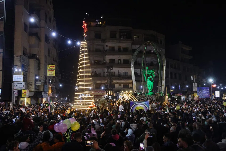 Para penduduk meraikan acara penyalaan pokok Krismas di kawasan Jaramana, yang majoritinya terdiri daripada komuniti Druze, di pinggir bandar Damsyik, Syria, pada 22 Disember.