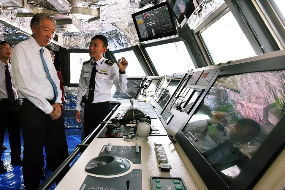 KAPAL BUATAN SINGAPURA: DPM Teo (dua dari kiri) mendengar taklimat daripada Ketua Pejabat Projek LMV RSN, Leftenan-Kolonel Chew Chun-Chau, semasa lawatan beliau ke Pusat Perintah Bersepadu kapal LMV itu. - Foto MINDEF