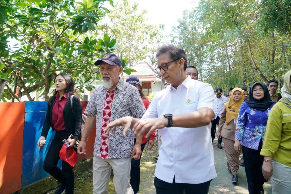 Menteri Kesihatan, Encik Budi Gunadi Sadikin, (kanan) dan Duta Muhibah Pertubuhan Kesihatan Sedunia (WHO) untuk Penghapusan Kusta, Encik Yohei Sasakawa, (kiri) dalam program bertemu dengan pesakit kusta yang telah pulih di Kampung Pamolaan, Sampang, Jawa Timur pada 8 Julai bagi menyuarakan penolakan terhadap stigma sosial berkaitan penyakit kusta.
